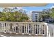 Balcony view showing the building's exterior, parking, landscaping, and blue skies at 2650 Pearce Dr # 301, Clearwater, FL 33764