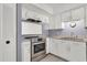 White kitchen with stainless steel stove and double sink at 3714 Greenery Ct # 214, Tampa, FL 33618