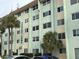 Asbury Arms exterior view, showing a multi-story building with palm trees and parked cars at 801 83Rd N Ave # 511, St Petersburg, FL 33702