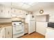 The kitchen is equipped with white appliances, bright lighting, and wood floors at 801 83Rd N Ave # 511, St Petersburg, FL 33702