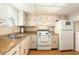 The kitchen is equipped with white appliances, bright lighting, and wood floors at 801 83Rd N Ave # 511, St Petersburg, FL 33702
