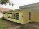 Rear view of house showcasing large windows and exterior door at 105 Causeway Blvd, Belleair Beach, FL 33786