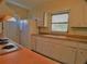 White kitchen cabinets, gas stove and exterior door at 105 Causeway Blvd, Belleair Beach, FL 33786