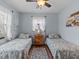 Two twin beds, ceiling fan, and wood-look floors in a light blue bedroom at 709 Mandalay Ave, Clearwater Beach, FL 33767