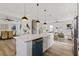 Open concept kitchen with white cabinets, island, and teal dishwasher at 4501 21St N St, St Petersburg, FL 33714