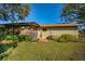 Home's backyard features a patio, lush landscaping and partial view of neighboring home at 1669 Fry Ct, Dunedin, FL 34698
