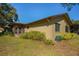 Backyard view of home with landscaping, screened enclosure and AC unit at 1669 Fry Ct, Dunedin, FL 34698