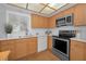 Modern kitchen with stainless steel appliances and light wood cabinets at 1669 Fry Ct, Dunedin, FL 34698