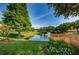 Serene pond with a wooden deck and fountain at 1669 Fry Ct, Dunedin, FL 34698