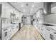 Long kitchen with white cabinets, quartz countertops and stainless steel appliances at 6602 S Emerson Ave, St Petersburg, FL 33707