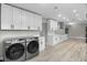 Laundry room with modern washer and dryer and white cabinets at 6602 S Emerson Ave, St Petersburg, FL 33707