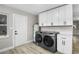 Bright laundry room with white cabinets and modern appliances at 6602 S Emerson Ave, St Petersburg, FL 33707