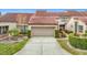 Spanish style home with a two-car garage and landscaping at 3076 Braeloch E Cir # 5, Clearwater, FL 33761