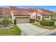 Tan two-story home with a two-car garage and manicured landscaping at 3076 Braeloch E Cir # 5, Clearwater, FL 33761