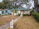 Adorable bungalow with a green metal roof, nicely landscaped yard, and a walkway at 728 Bay St, Dunedin, FL 34698