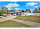 Landscaped yard with a curved driveway leading to a one-story home at 9143 Bay Dr, Spring Hill, FL 34606