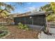 Backyard view of home with screened porch and garden at 9402 Forest Hills Cir, Tampa, FL 33612