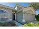 House exterior featuring a two-car garage and walkway at 12818 Royal George Ave, Odessa, FL 33556