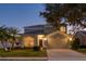 Two-story house with attached garage and well-manicured lawn at dusk at 12818 Royal George Ave, Odessa, FL 33556