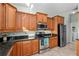 Modern kitchen with wood cabinets, granite countertops, and stainless steel appliances at 12818 Royal George Ave, Odessa, FL 33556