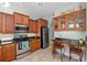 Kitchen features wood cabinets, granite countertops, and stainless steel appliances at 12818 Royal George Ave, Odessa, FL 33556