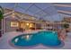 Lovely screened pool with waterfall feature at dusk at 12818 Royal George Ave, Odessa, FL 33556