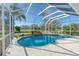 Inviting kidney-shaped pool with waterfall feature, screened enclosure at 12818 Royal George Ave, Odessa, FL 33556
