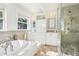 Bright bathroom with a soaking tub, glass enclosed shower, and and sink vanities at 2001 Beach Se Dr, St Petersburg, FL 33705