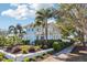 Charming blue two-story home with landscaped yard, palm trees, and a stone walkway at 2001 Beach Se Dr, St Petersburg, FL 33705