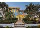 Two-story light blue home with lush landscaping, a brick walkway, and a covered porch at 2001 Beach Se Dr, St Petersburg, FL 33705