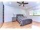 Bright bedroom with a gray upholstered bed, wood floors, and built-in shelving at 5357 Cobblestone Ct, Wesley Chapel, FL 33543