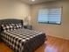Cozy bedroom featuring a gray upholstered bed and wood floors at 5357 Cobblestone Ct, Wesley Chapel, FL 33543