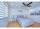 Bright bedroom featuring a queen-size bed, hardwood floors, and ceiling fan at 5357 Cobblestone Ct, Wesley Chapel, FL 33543