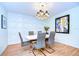Elegant dining room with white table, gray chairs, and a chandelier at 5357 Cobblestone Ct, Wesley Chapel, FL 33543