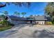 Gray house with a dark gray roof and landscaping at 5357 Cobblestone Ct, Wesley Chapel, FL 33543