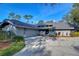 Gray house with a gray shingle roof and landscaping at 5357 Cobblestone Ct, Wesley Chapel, FL 33543