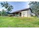 Landscaped backyard with home exterior view, showcasing a spacious lawn at 807 Belle Timbre Ave, Brandon, FL 33511