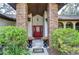 Elegant entryway with brick columns, a red door, and ornate planters at 807 Belle Timbre Ave, Brandon, FL 33511
