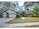 Brick house with three-car garage, mature landscaping, and a large front yard at 807 Belle Timbre Ave, Brandon, FL 33511