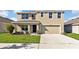 Two-story house with a two-car garage and a well-manicured lawn at 16743 Carlton Pond St, Wimauma, FL 33598
