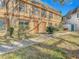 Tan two-story building with brown doors and shutters, surrounded by grass and landscaping at 4405 Vieux Carre Cir # 46, Tampa, FL 33613