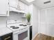 Kitchen with white cabinets, stove, and white tile at 4405 Vieux Carre Cir # 46, Tampa, FL 33613