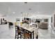 Open concept dining room with modern light fixture, and view into living room at 6208 Spoonbill Dr, New Port Richey, FL 34652