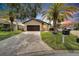 Single-story home with a dark brown garage door, paver driveway, and landscaping at 6208 Spoonbill Dr, New Port Richey, FL 34652
