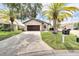 Single-story house featuring a paver driveway and palm trees at 6208 Spoonbill Dr, New Port Richey, FL 34652
