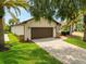 House exterior with a two-car garage and inviting landscaping at 6208 Spoonbill Dr, New Port Richey, FL 34652