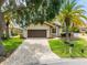 House exterior with a two-car garage and well-manicured lawn at 6208 Spoonbill Dr, New Port Richey, FL 34652