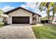Single story house with dark brown garage door and paver driveway at 6208 Spoonbill Dr, New Port Richey, FL 34652