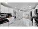 Bright kitchen with white cabinets, black countertops, and stainless steel appliances at 6208 Spoonbill Dr, New Port Richey, FL 34652