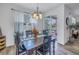 Dining area with wood floors, stylish lighting fixture and view of the backyard pool through sliding glass doors at 8272 Artisan Way, Seminole, FL 33777